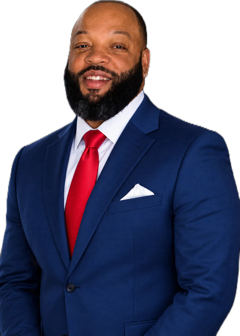 Anthony Cook in a navy suit and red tie